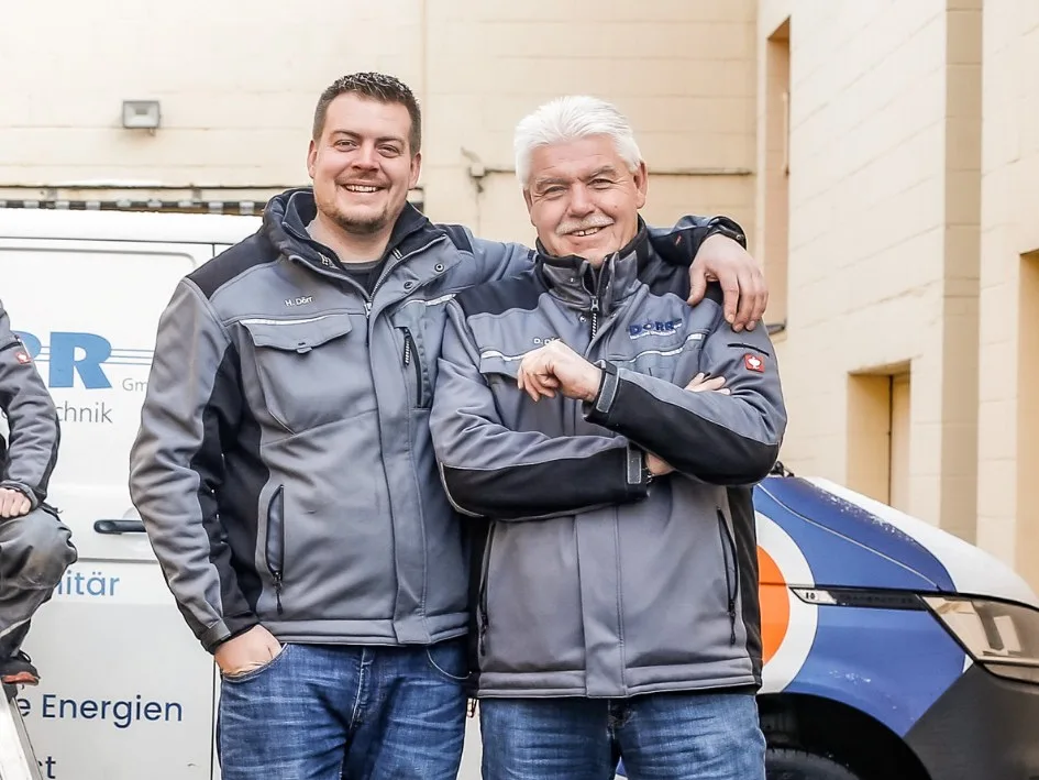 Henrik Dörr und Dieter Dörr in DÖRR-Arbeitsjacken vor einem Firmenwagen